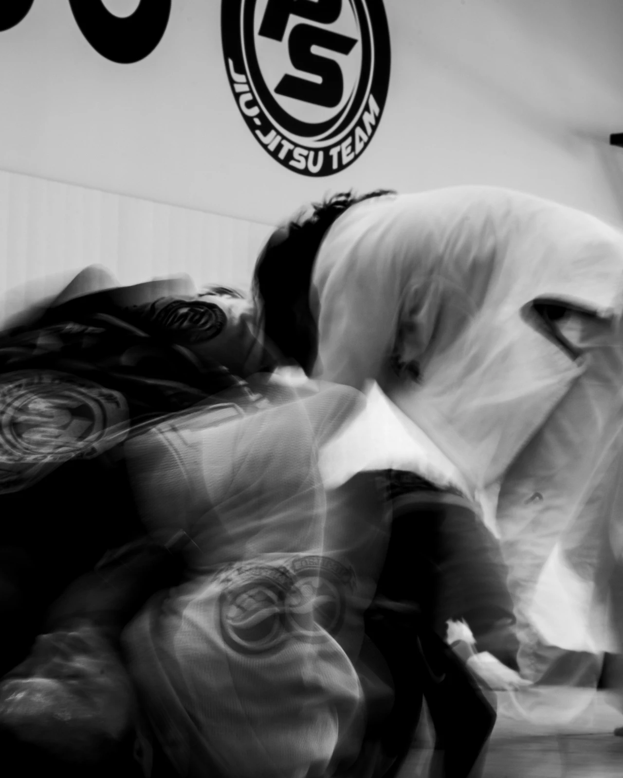 Black-and-white action photograph of jiu-jitsu athletes training
